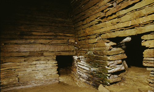 A brick wall chamber inside the cairn with two openings in its walls