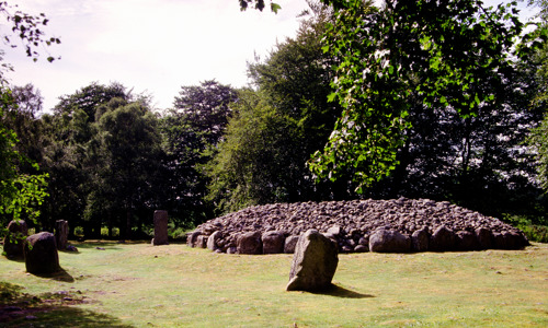 A few small standing stones surround a low stone cairn