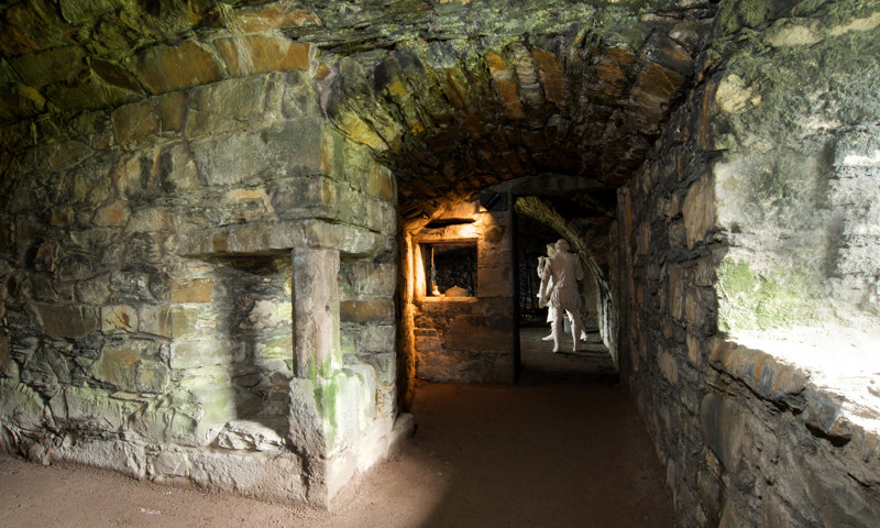 An interior view looking down a passage towards the kitchen at MacLellan’s Castle.