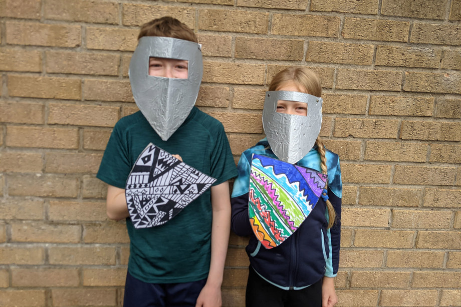 Boy and girl with their homemade jousting helmets and shield