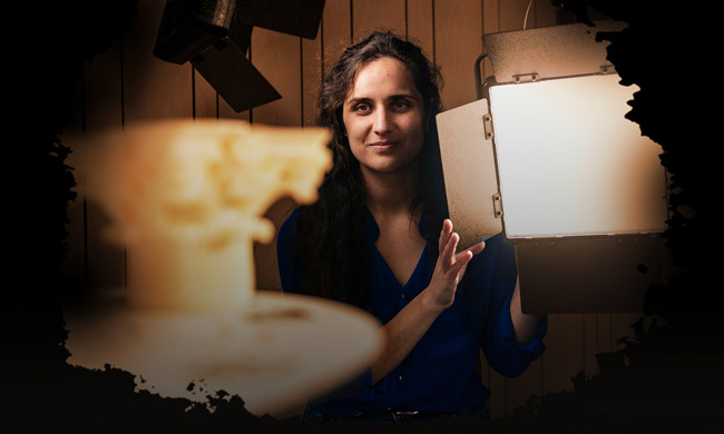 A woman adjusting a light box and working on 3D scanning