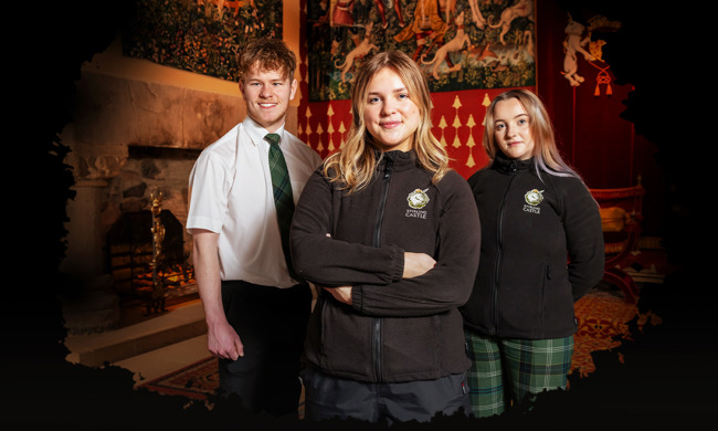 Three staff from Stirling Castle in the Royal Palace wearing the castle tartan uniform