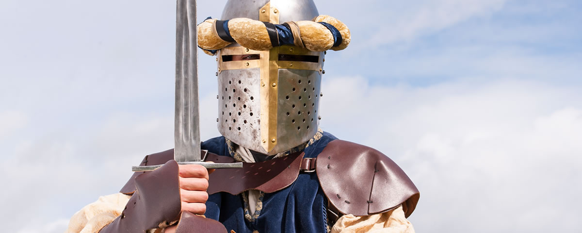 A re-enactor wearing a knight’s armour and holding a sword.