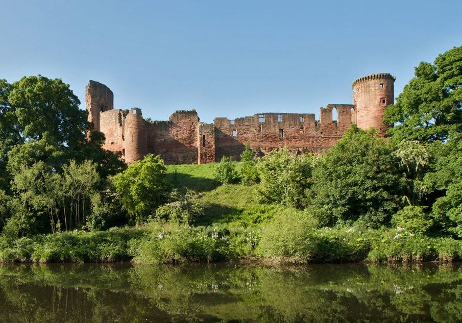 An exterior view of Bothwell Castle, nestled among trees on the River Clyde.
