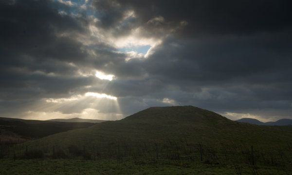 The mound that forms Knowes O’ Trotty chambered cairn at dusk.