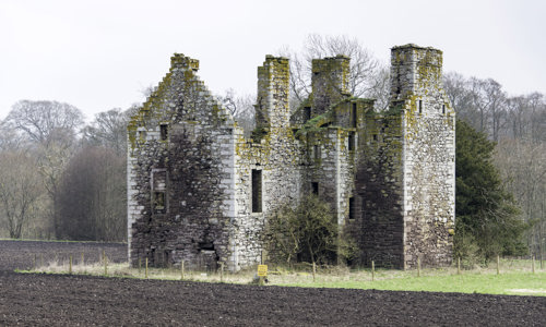 The remains of Innerpeffray Castle, on the edge of some farmland.