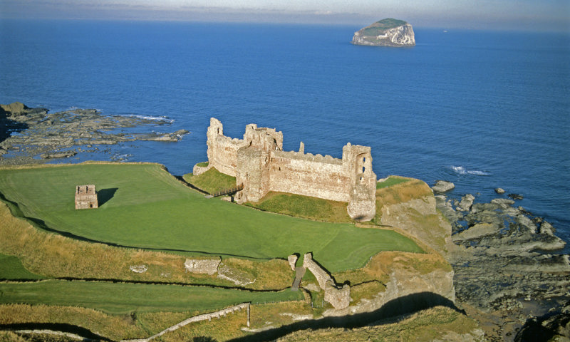 An aerial view of Tantallon Castle, with Bass Rock visible in the background.