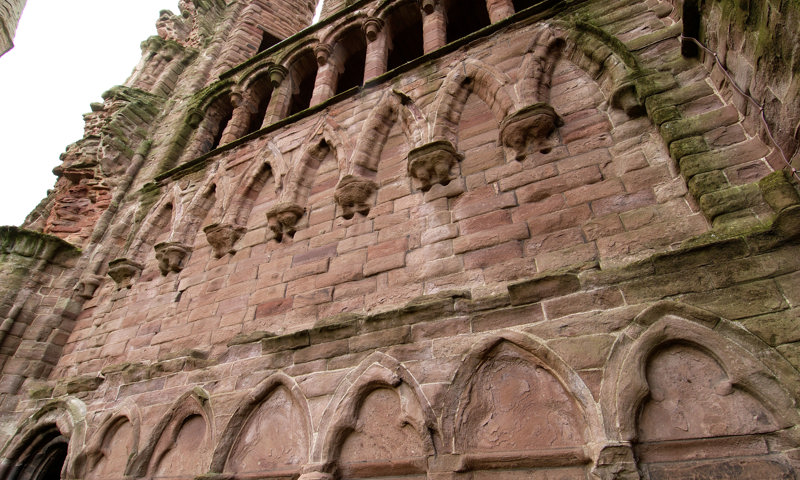A detail of some of the stonework on a red brick wall at Arbroath Abbey.
