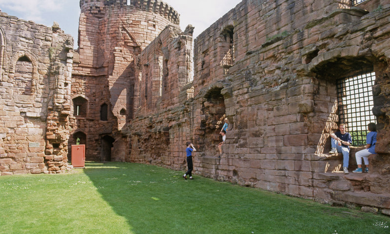 Visitors relaxing in the courtyard at Bothwell Castle.