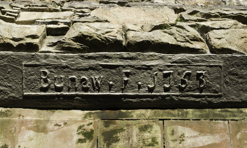 The words “Bunaw F 1753" are seen inscribed on a panel at Bonawe Iron Furnace.