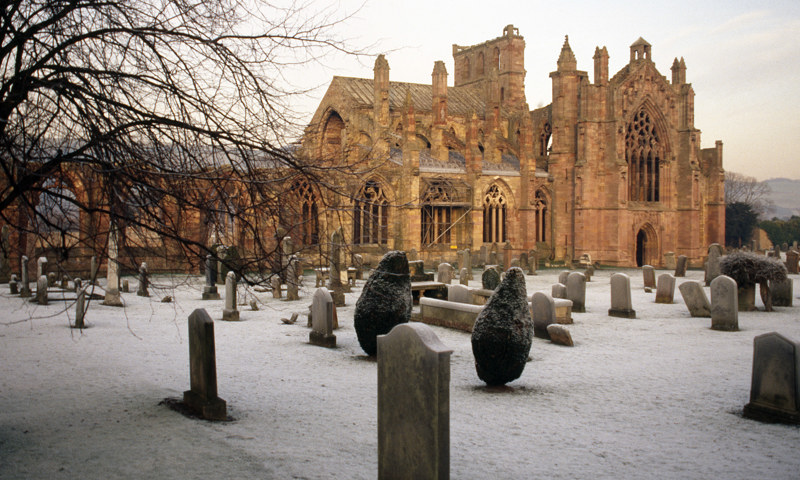 A general view of Melrose Abbey and graveyard during winter.