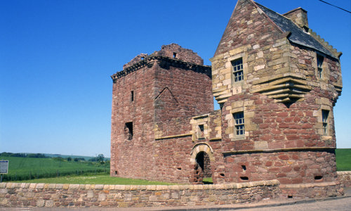  A three-storey roofless tower house, with an attached corner tower that has a playful oversailing top.