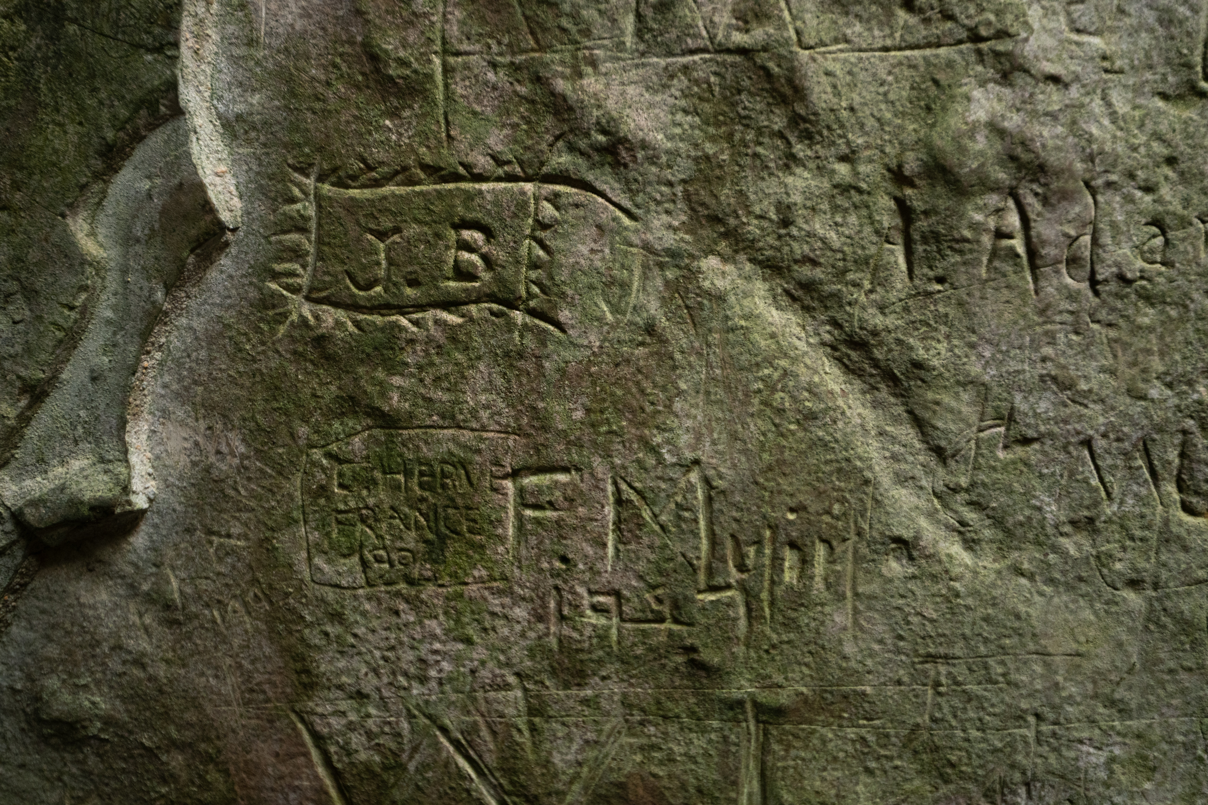 Carvings including initials into a ancient slab of stone
