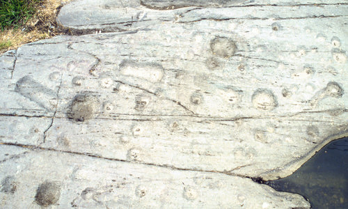 A variety of marks carved into rock.