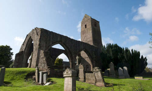 A few gravestones stand in front of Muthill church, which has a large square tower on the right
