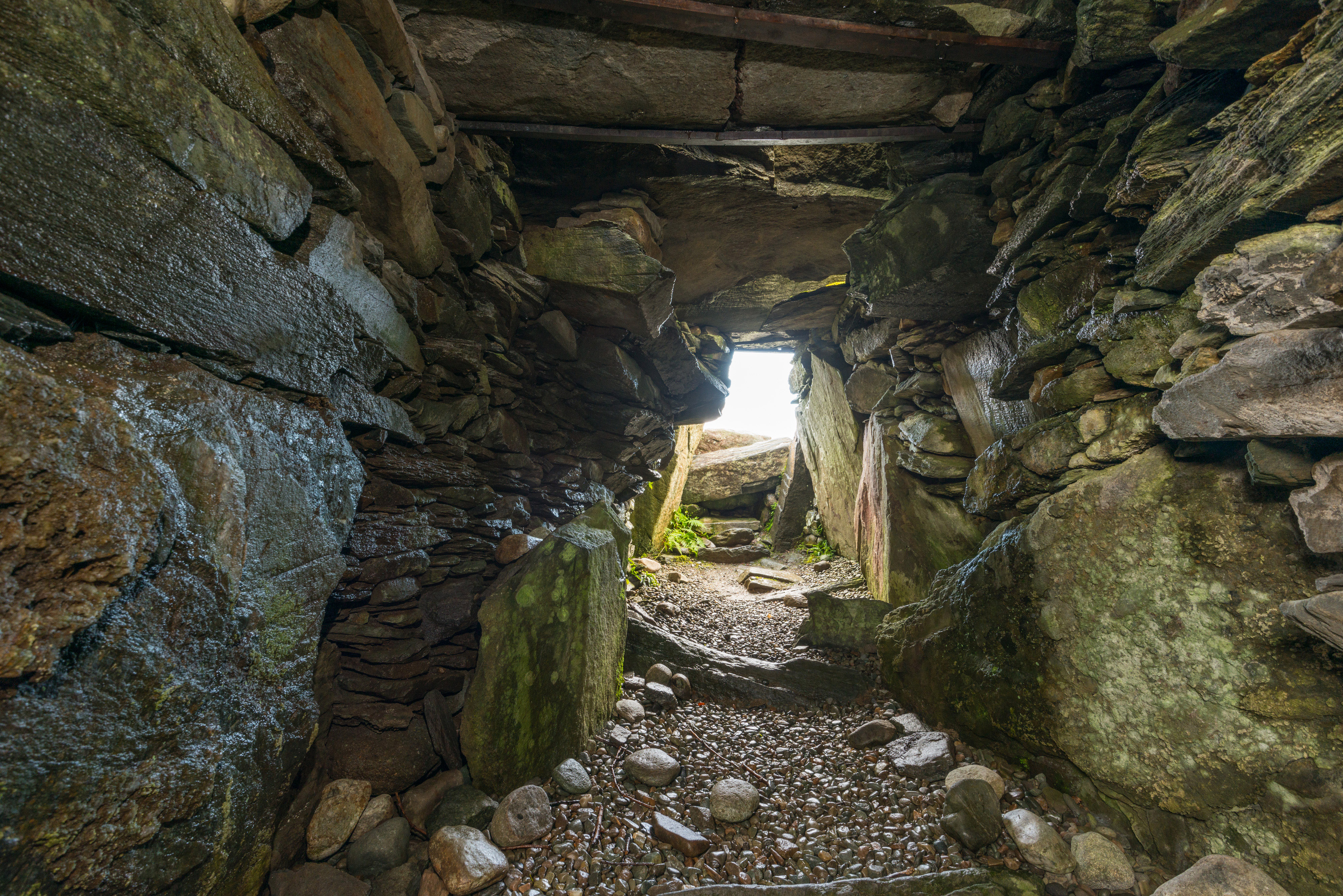 A low stone passage leading out of a cairn.