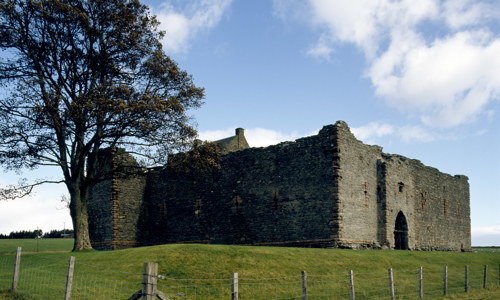 The square, well preserved Skipness Castle ruin on a grassy hill