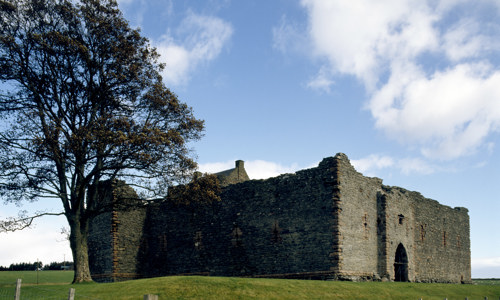 The square, well preserved Skipness Castle ruin on a grassy hill