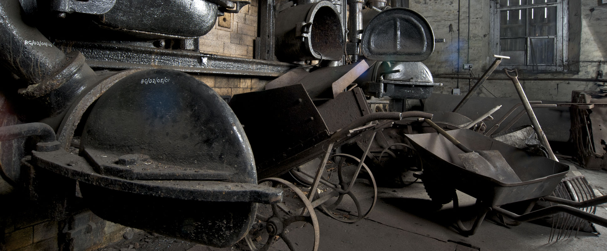 A photograph of wheelbarrows and industrial equipment inside a building