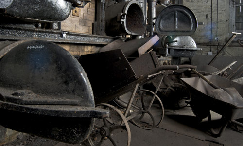 A photograph of wheelbarrows and industrial equipment inside a building