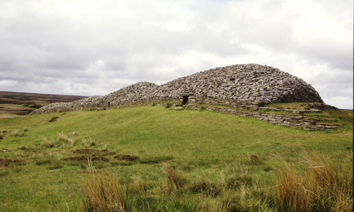 A well preserved stone cairn on a grassy landscape