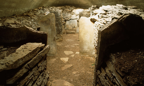 The underground remains of a stone cairn covered by a modern ceiling