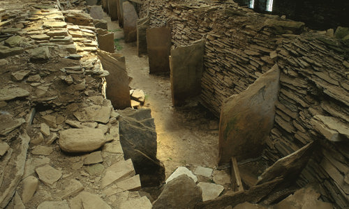 Two thick stone walls with smaller stone slabs standing in between them