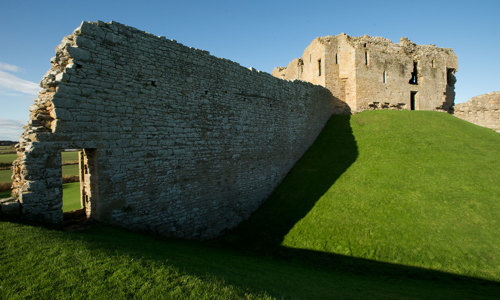 A ruined wall stretches out from the remains of Duffus Castle