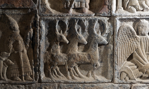 A detailed view of a stone carving that shows three stags