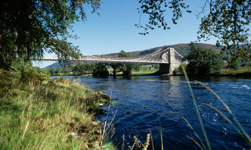 A white and grey suspension bridge spanning the river Oich.
