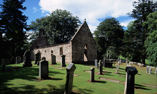 A roofless but other wise intact church in a wooded area