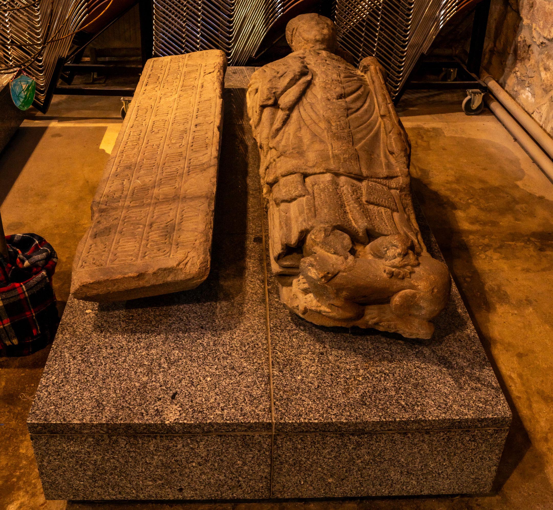 Carved medieval effigy and decorated grave slab on granite plinth in transepts.