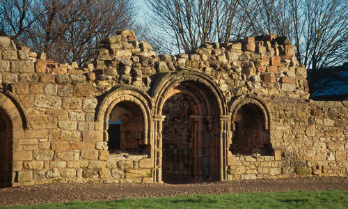 The remains of a decorated gate and two windows in the wall beside it