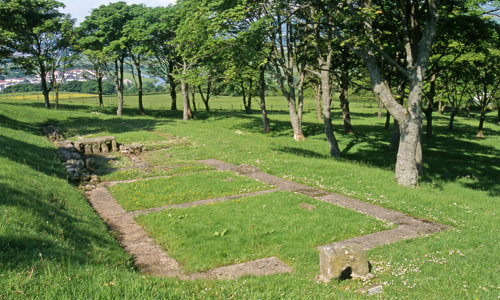 The foundations of a rectangular building surrounded by trees 