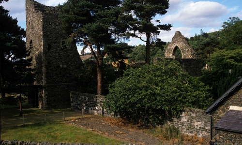 A roofless church ruin surrounded by trees