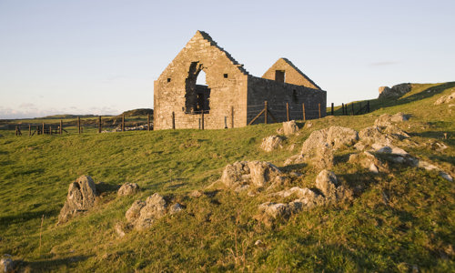 A small roofless chapel in a sunlit field