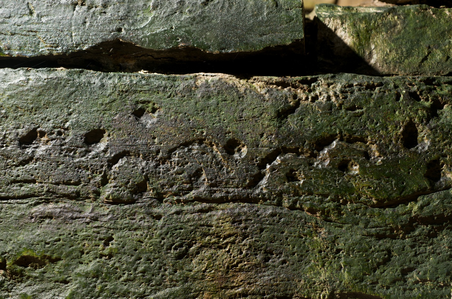 A section of a stone, which has some carving detail on the side of it. 
