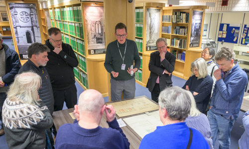 a group of people round a table looking at archive documents