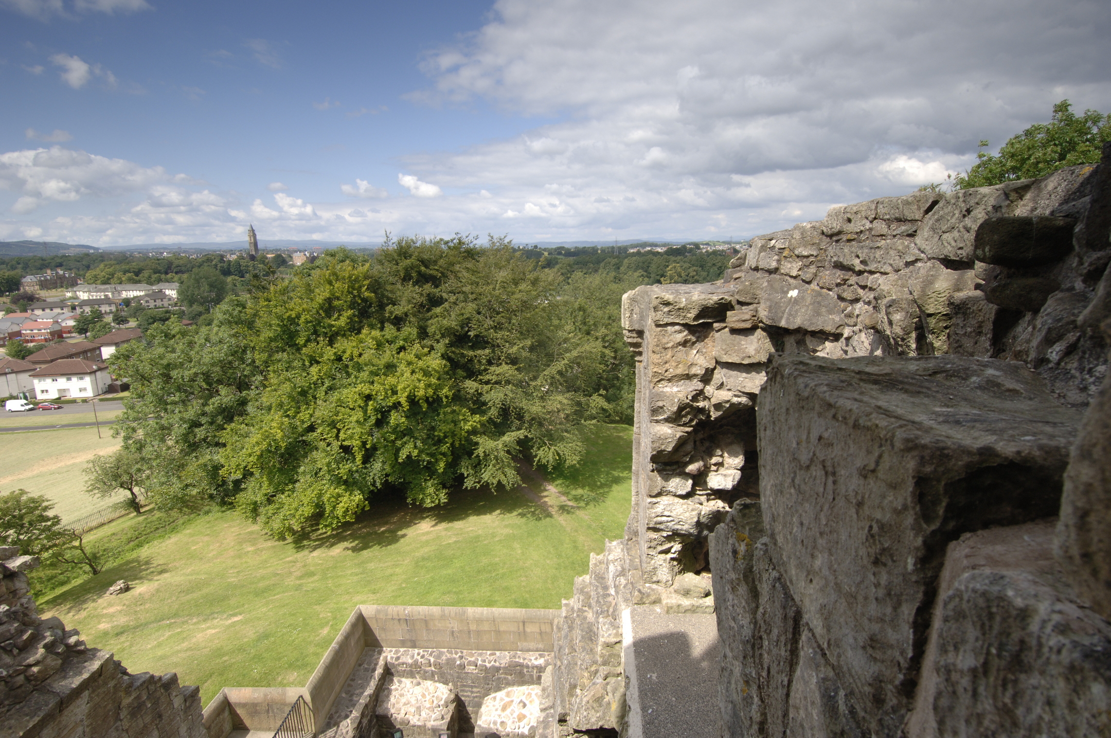 View across trees and a meadow from Crookston Castle