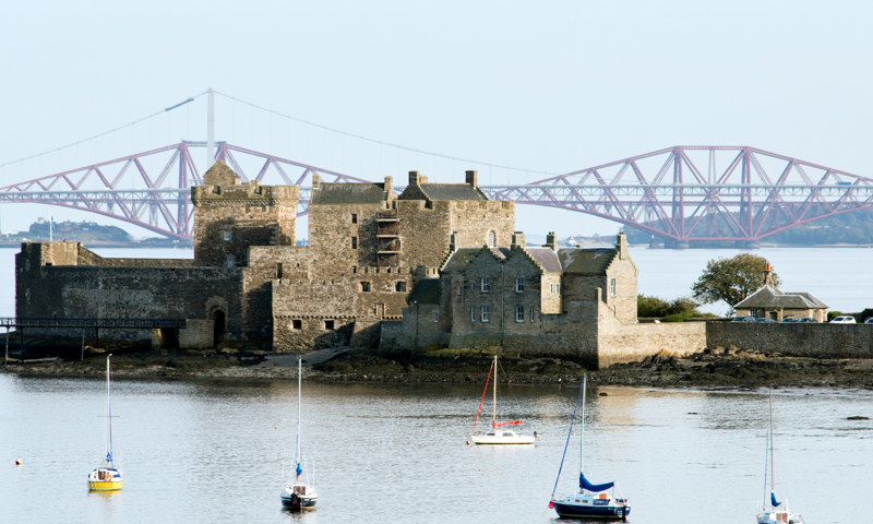 Blackness Castle on the Firth of Forth, with the Forth Rail Bridge behind it.