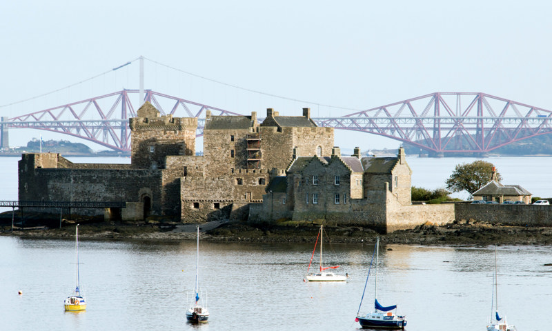 Blackness Castle on the Firth of Forth, with the Forth Rail Bridge behind it.