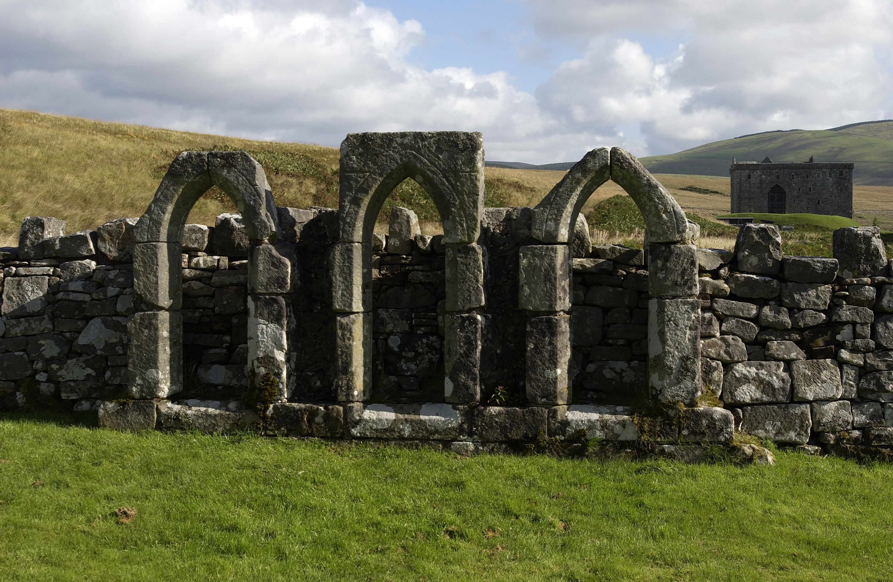 An exterior view of the lancet windows from the chapel at Hermitage Castle.