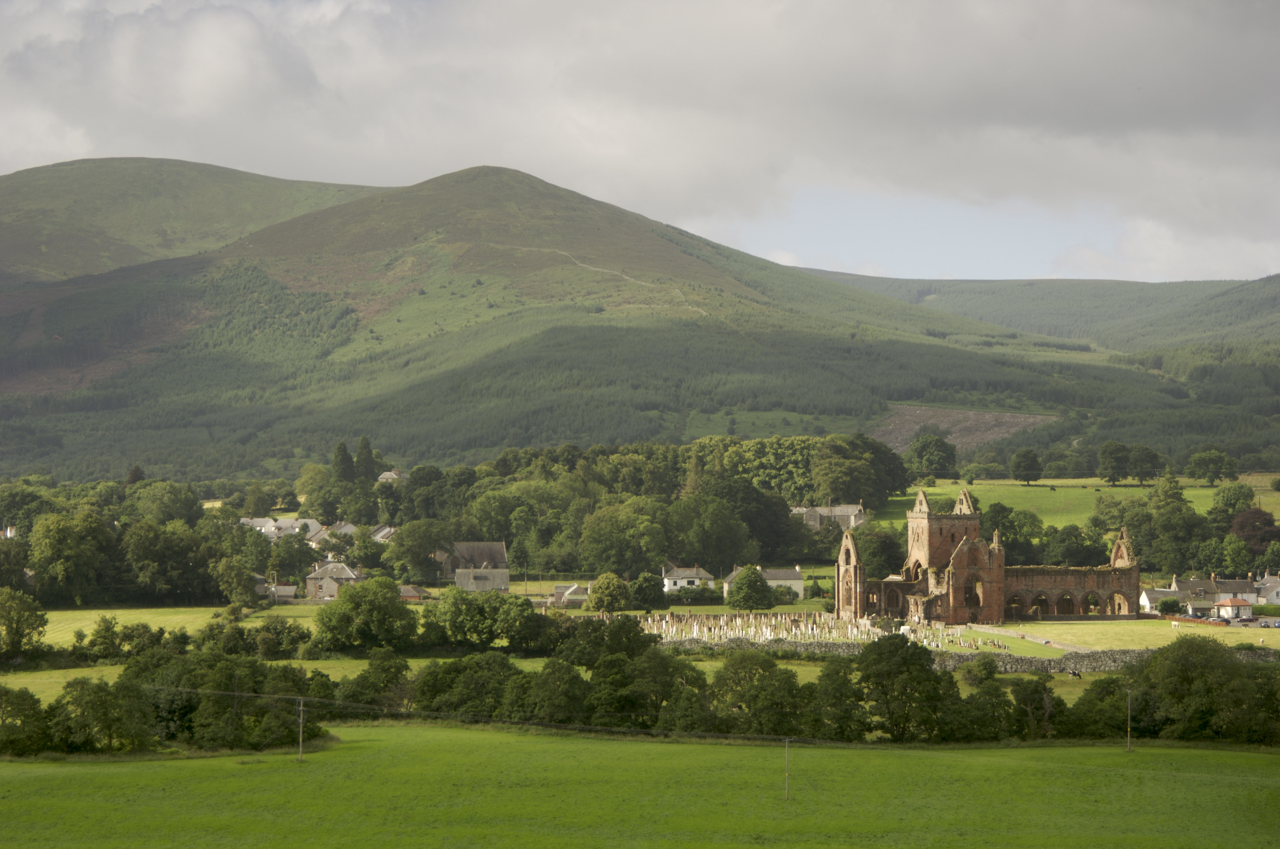 A distant view of Sweetheart Abbey and the surrounding countryside.
