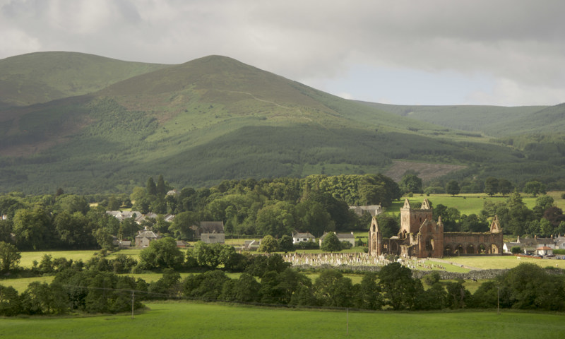 A distant view of Sweetheart Abbey and the surrounding countryside.