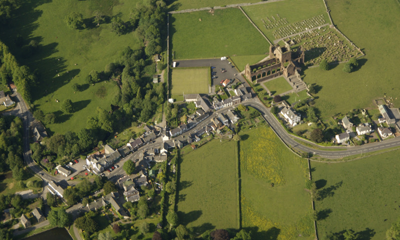 An aerial view of Sweetheart Abbey and the village of New Abbey.
