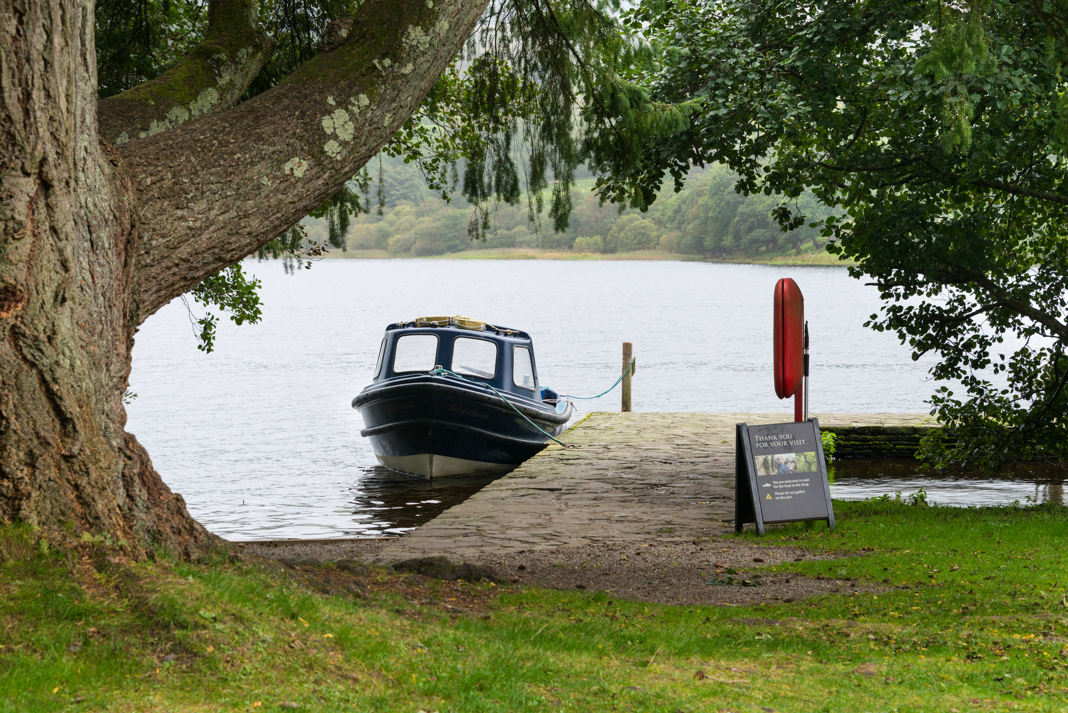 A small blue boat moored at a stone jetty 