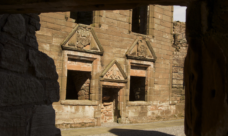 An interior view of the Nithsdale Lodging at Caerlaverock Castle, showing fine stone carvings above the doors and windows