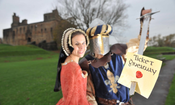 Re-enactors dressed as a knight and medieval lady advertise a ticket giveaway outside Linlithgow Palace.