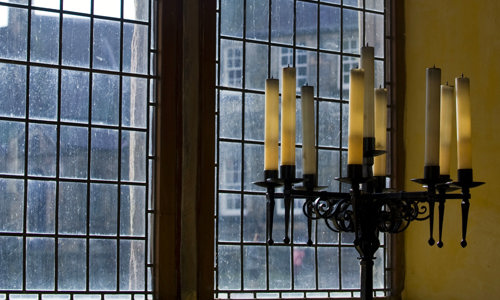 A candle and window inside the great hall at Stirling Castle.