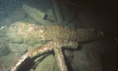 2 anchors and a gun from a merchant vessel lie against the base of a steep underwater cliff within the Kinlochbervie HMPA (© Crown Copyright HES)